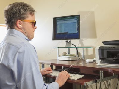 white man with shades typing on computer
